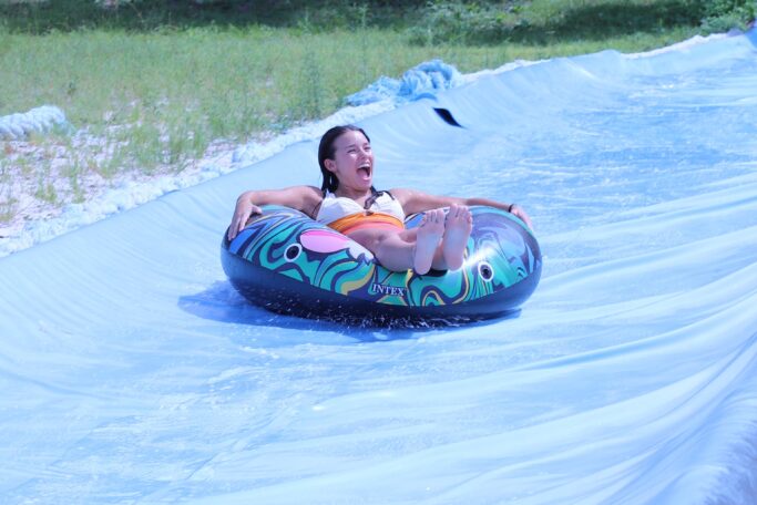 A woman experiencing the spiritual thrill of life as she rides down a water slide.