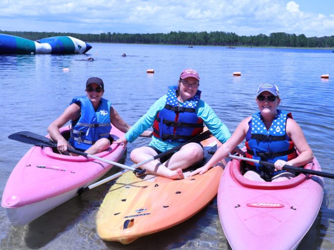 A group of people engaging in a spiritual life activity on a kayak.