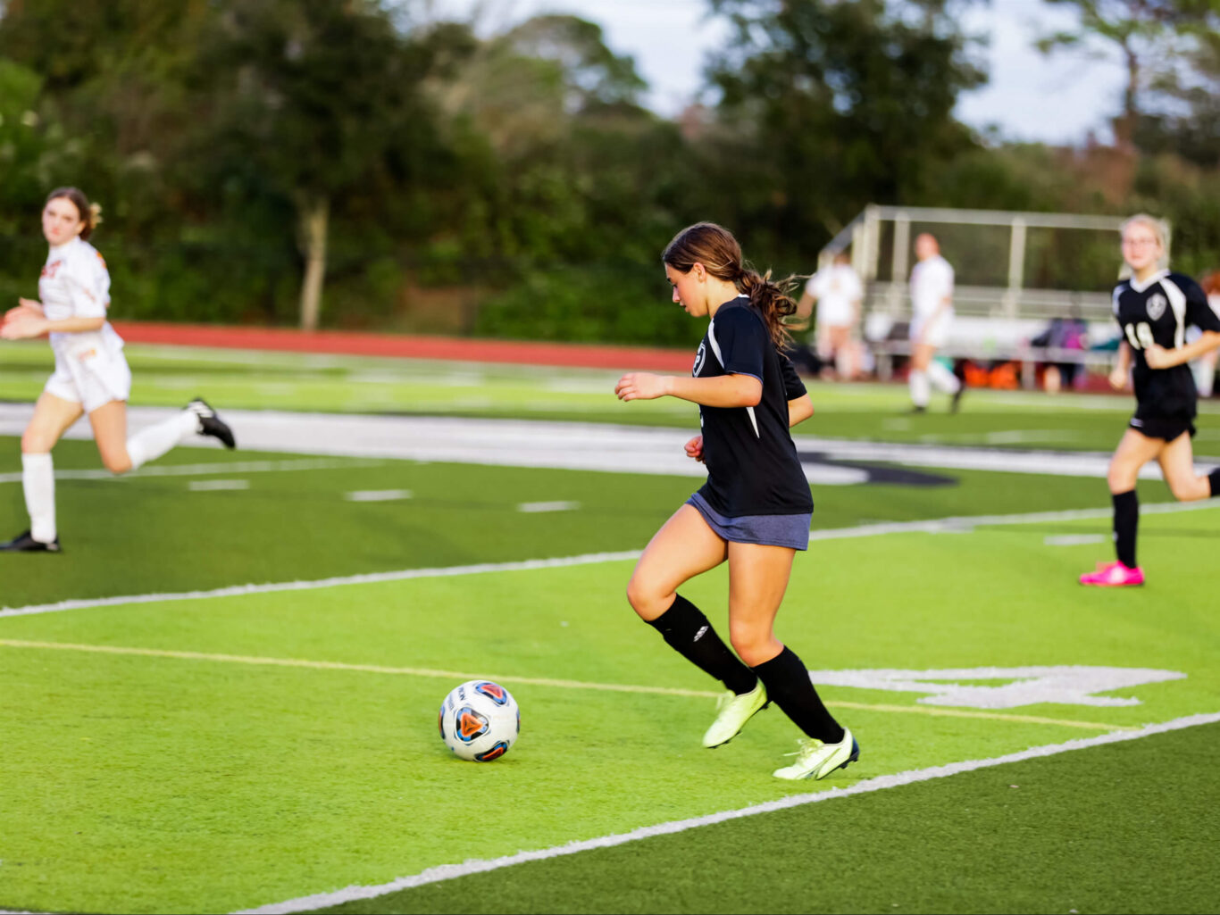 A girl playing soccer on a field.