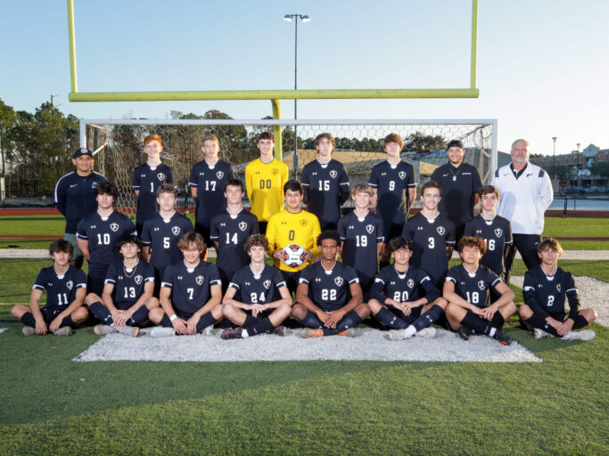 A boys' soccer team is posing for a team photo.