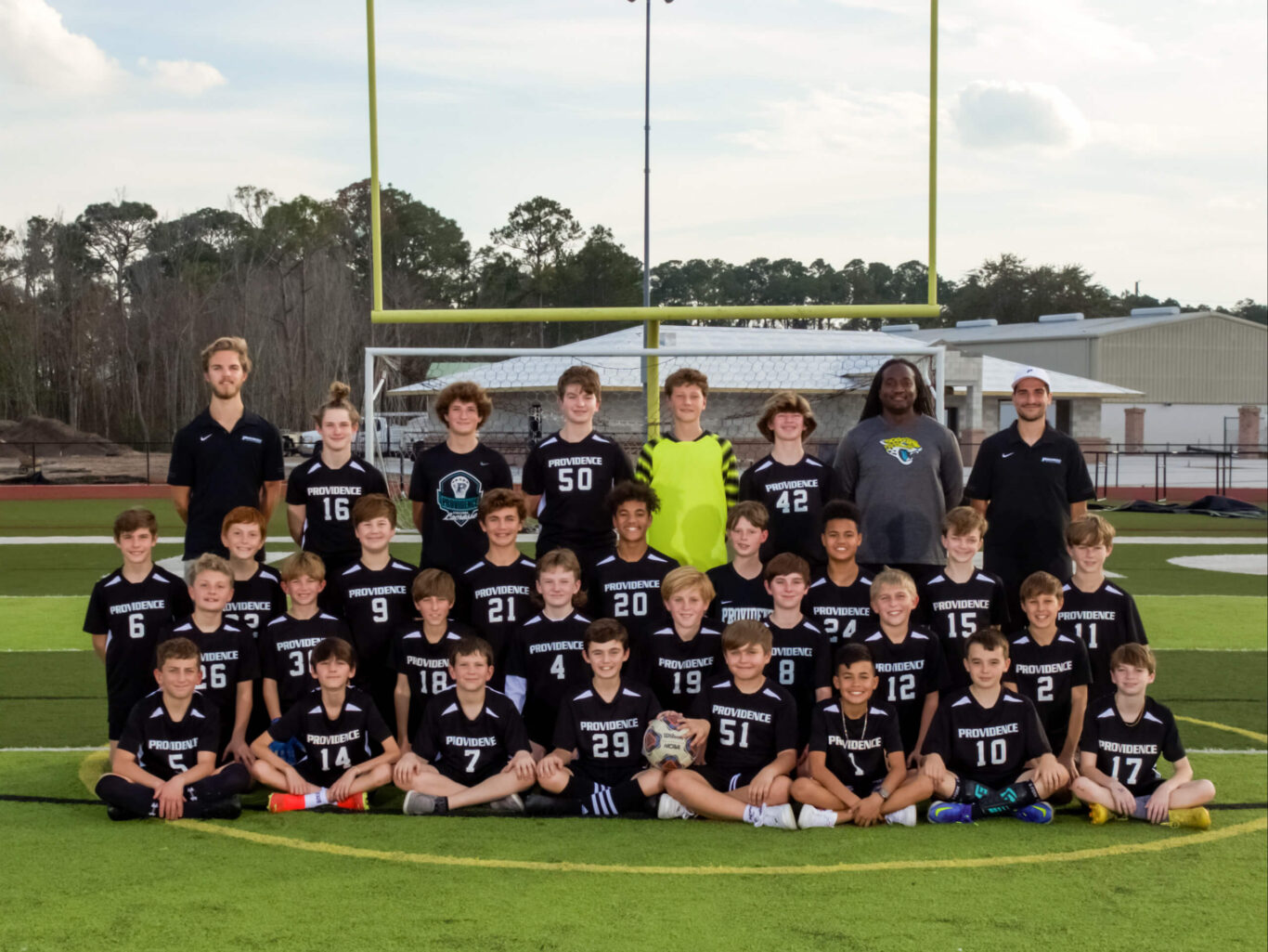 A group of boys is posing for a soccer team photo.