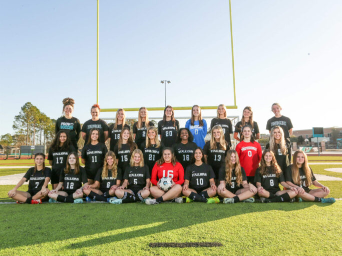 The girls soccer team is posing for a photo.