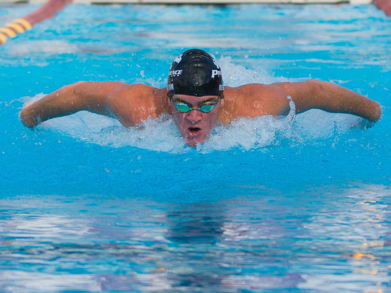 A boy is swimming in a pool.