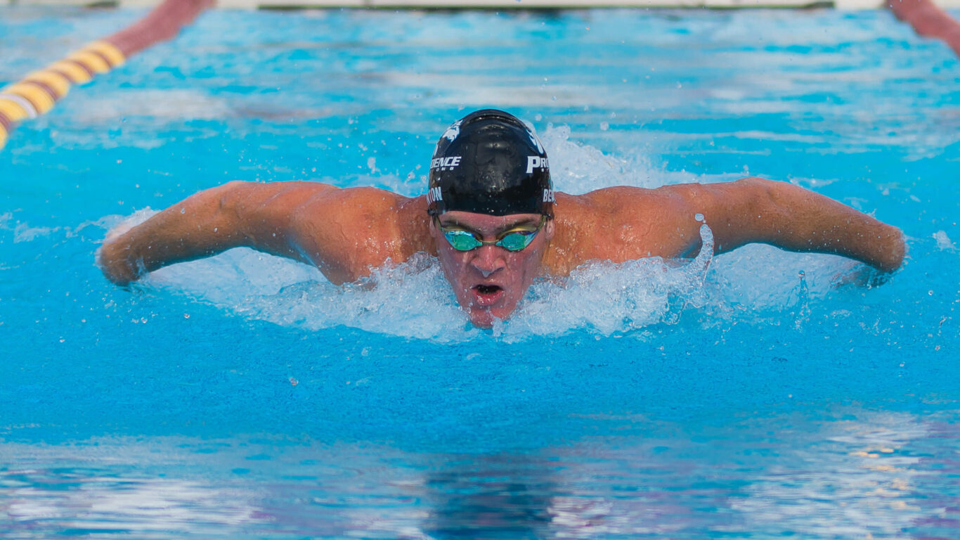 A man is swimming in a pool.