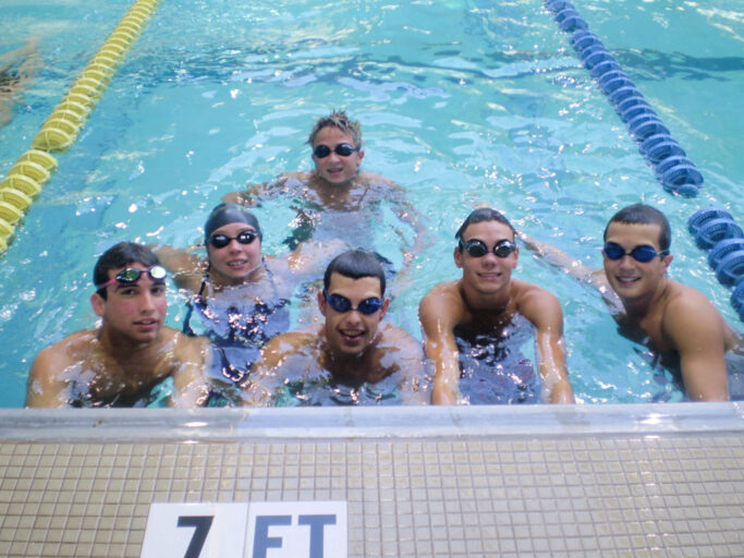 A group of boys swimming in a pool.