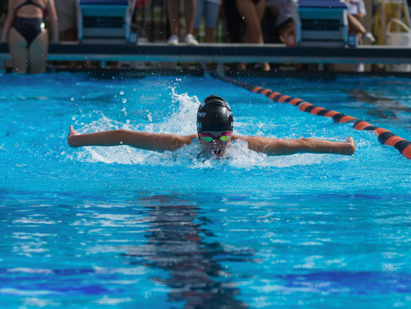 A girl is swimming in a pool.