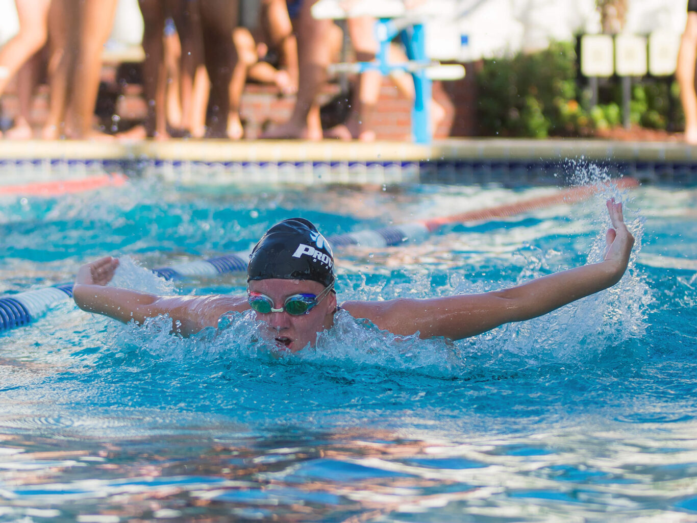 A girl is swimming in a pool.