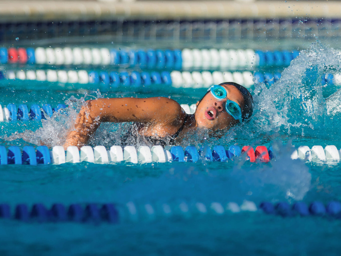 A girl is swimming in a pool.