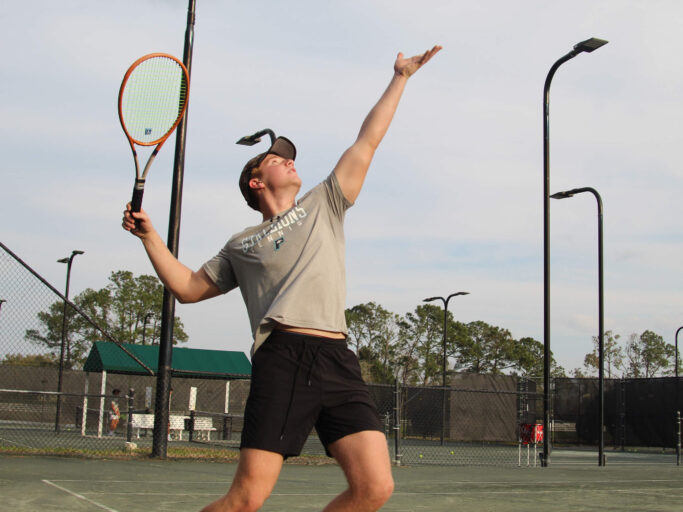 A man playing tennis on a tennis court.