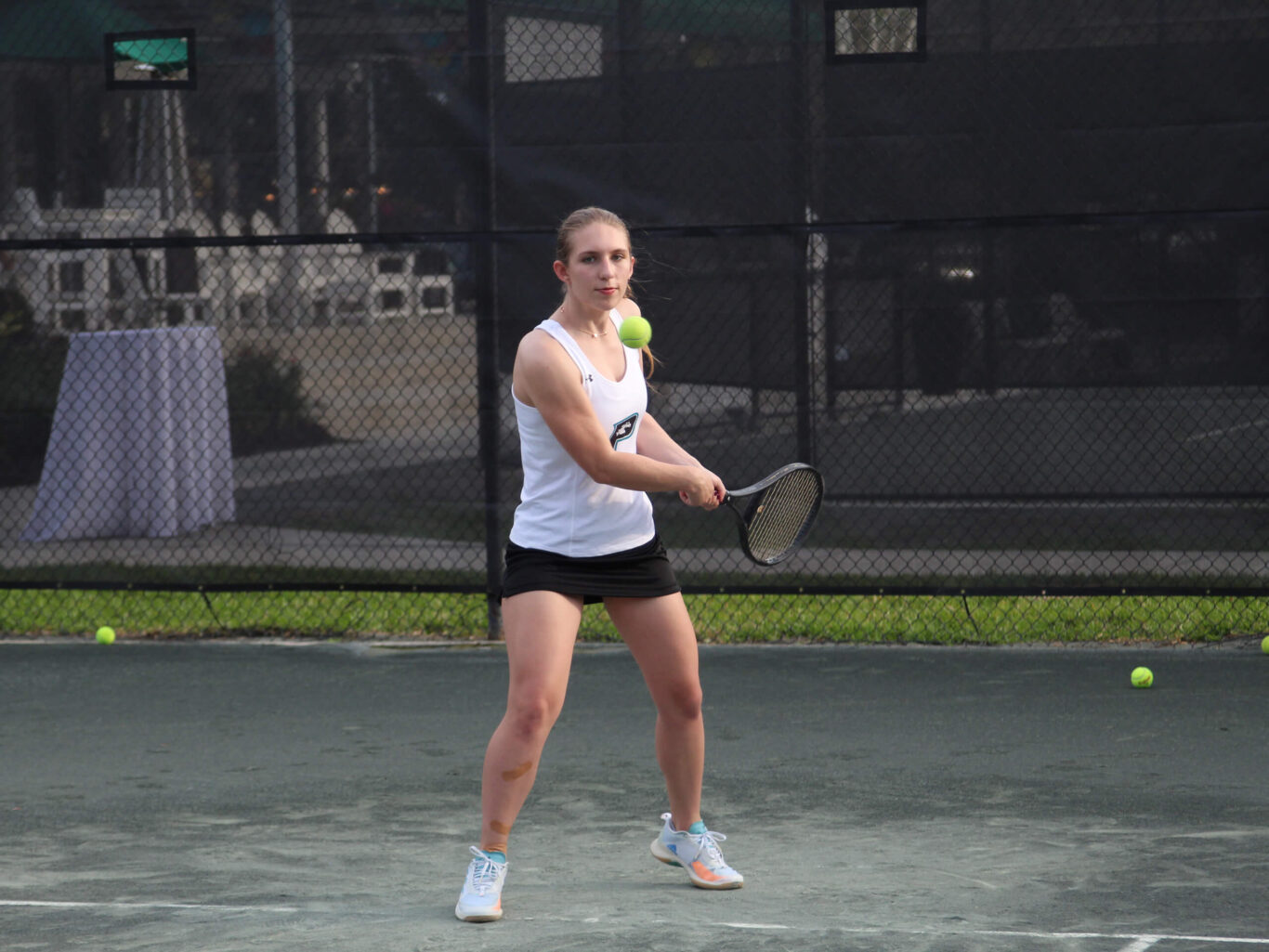A girl wielding a tennis racket on a tennis court.