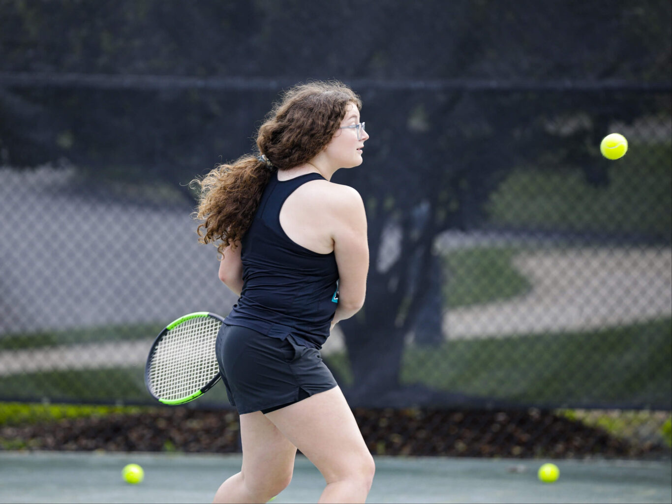 A girl playing tennis with a tennis racket.