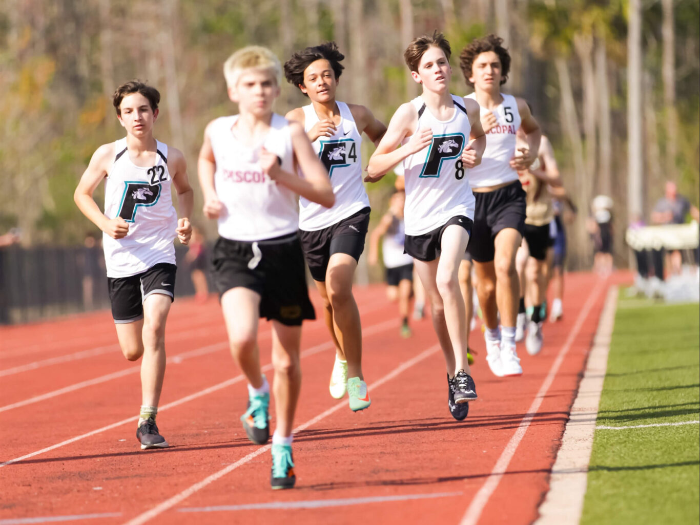 A group of boys running on a track.