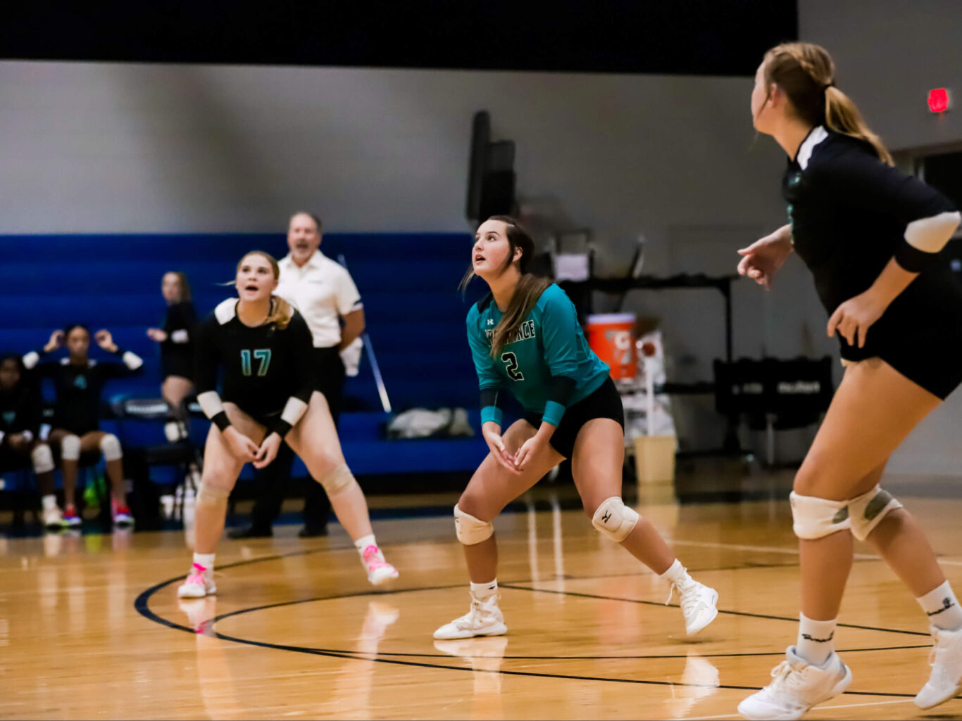 A group of girls passionately playing volleyball on a court.