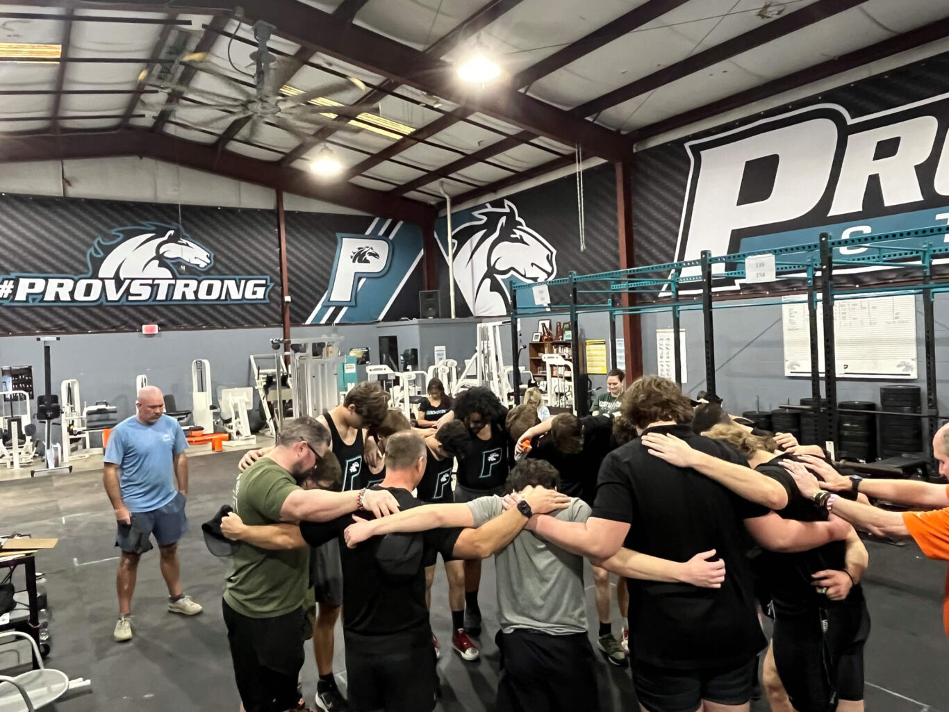 A group of boys huddle together in a gym.