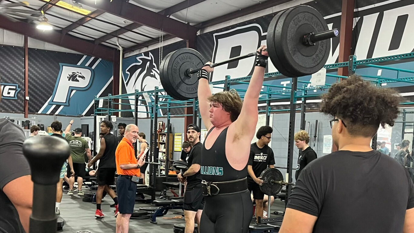 A man engaging in weightlifting at a gym.