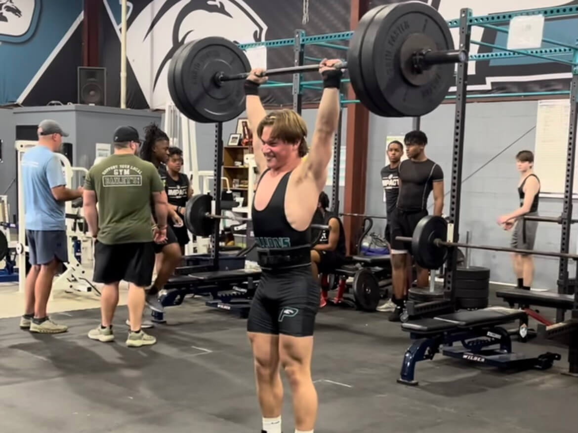 A weightlifting enthusiast lifting a barbell in a gym.
