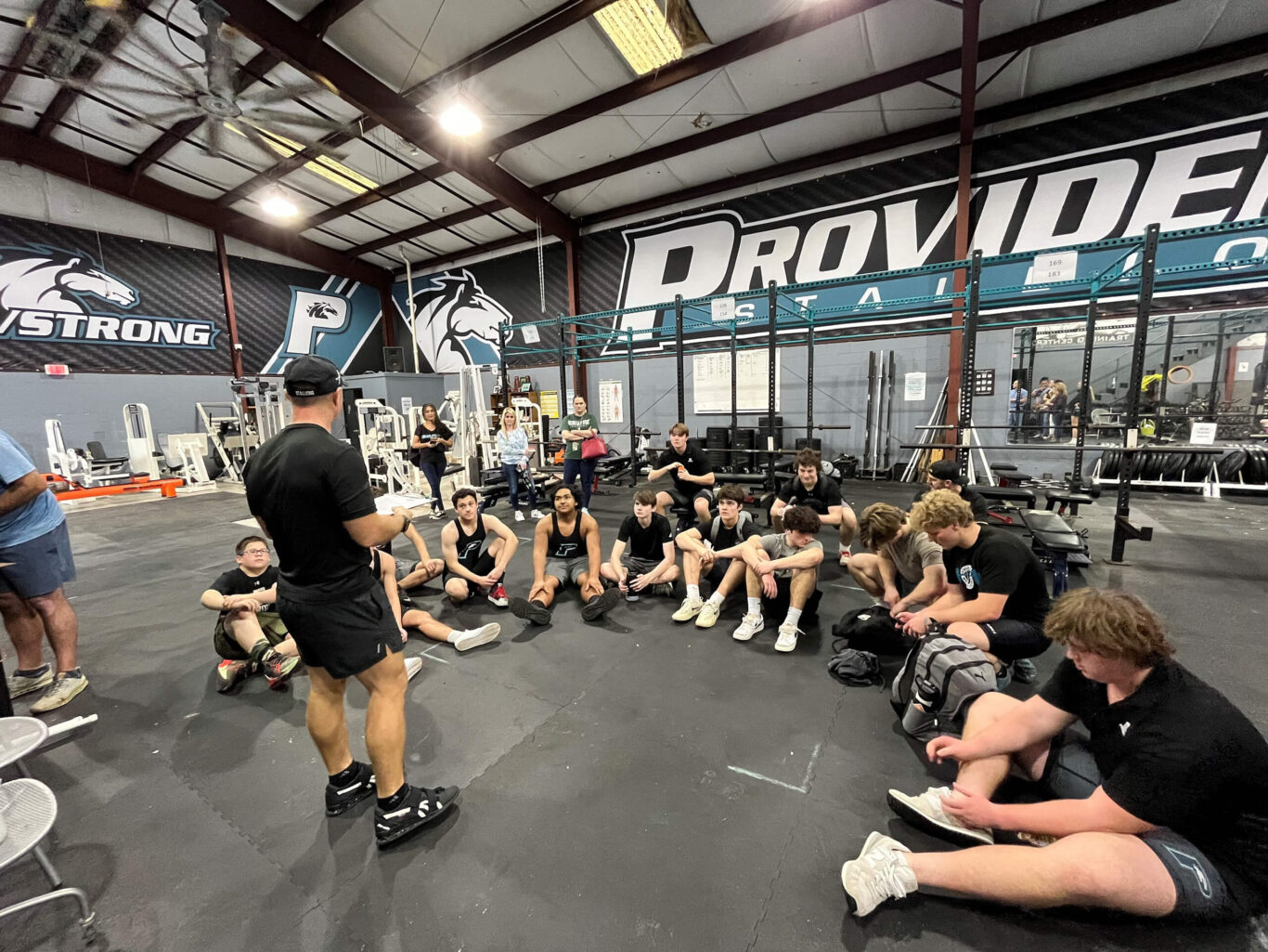 A group of boys weightlifting in a gym.