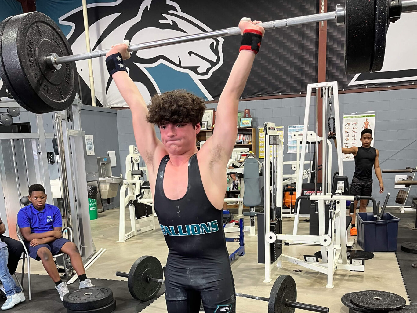 A man weightlifting in a gym.